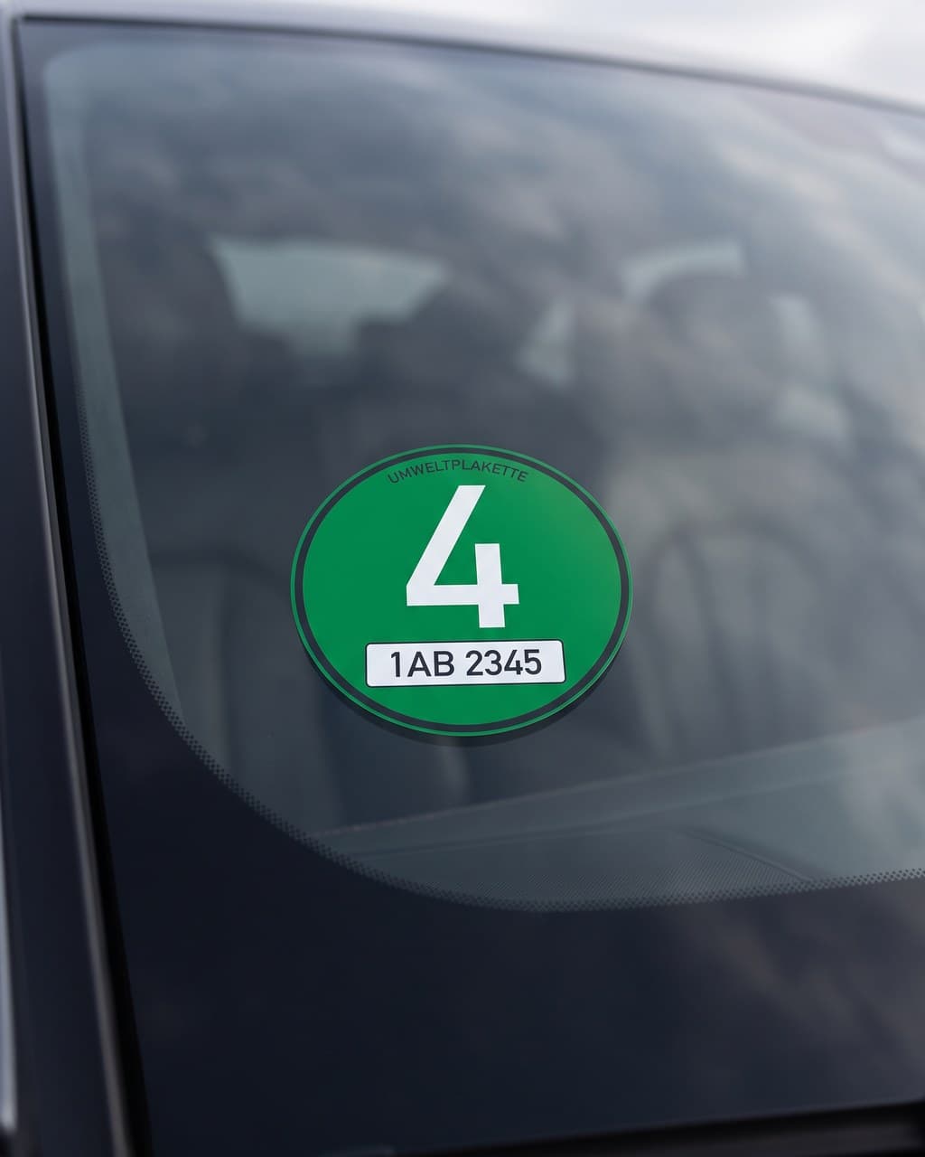 Zelená ekologická plaketa s registrační značkou nalepená na čelním skle auta